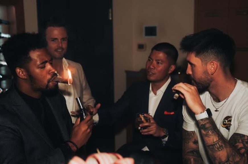 Members lighting cigars together